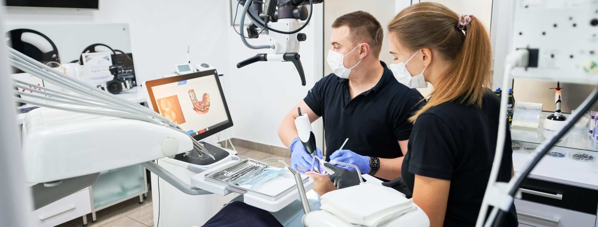 Un dentiste et son assistante dentaire qui prennent une empreinte à l'aide d'une caméra intra-orale